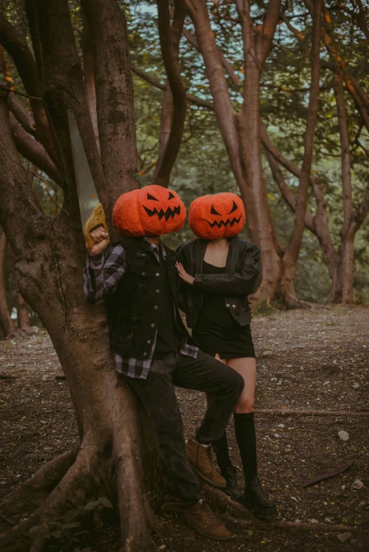 two people in costumes posing by a tree