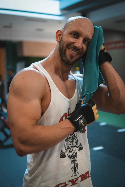 a man holding up a green towel in a gym