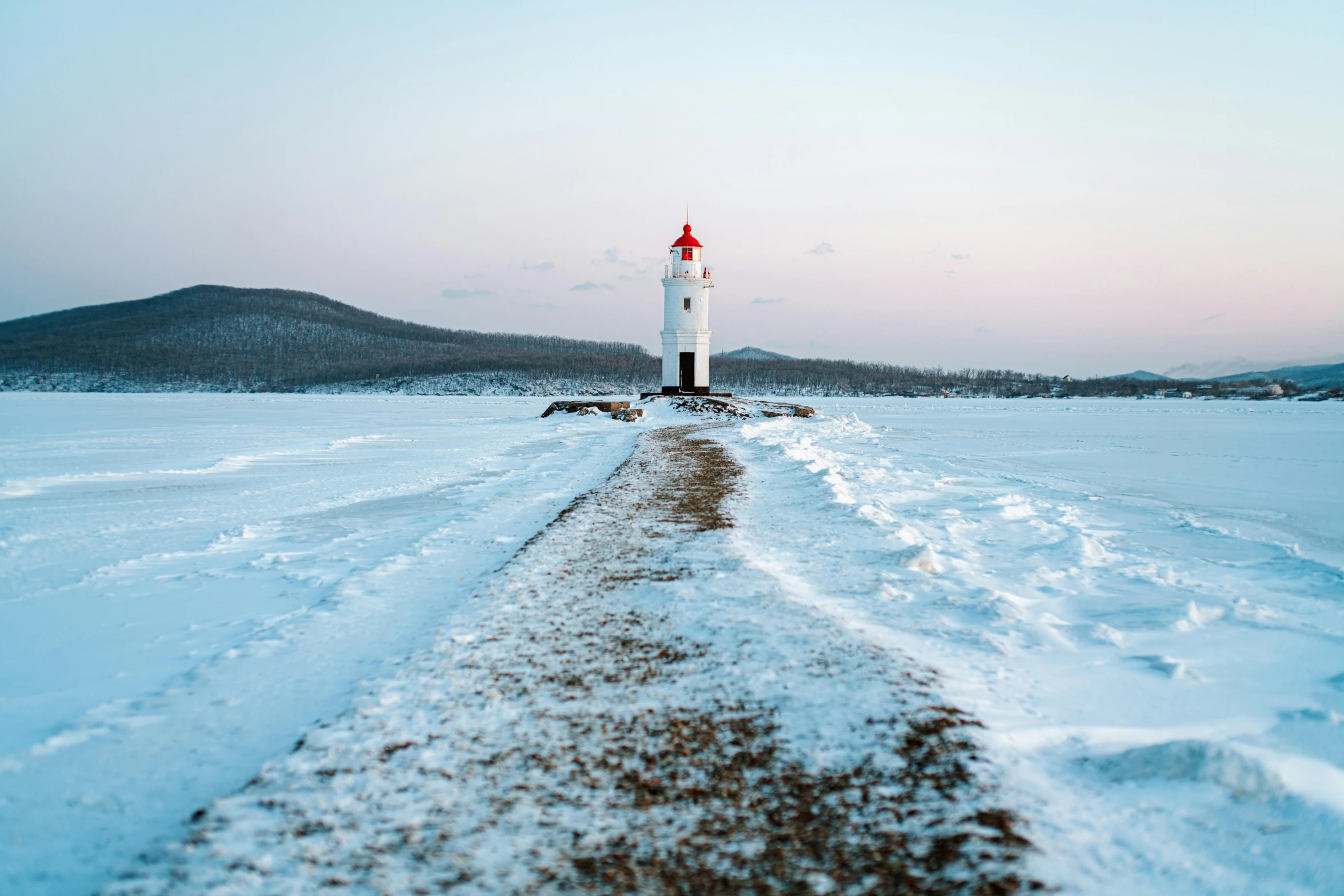 a large body of water next to a white light house