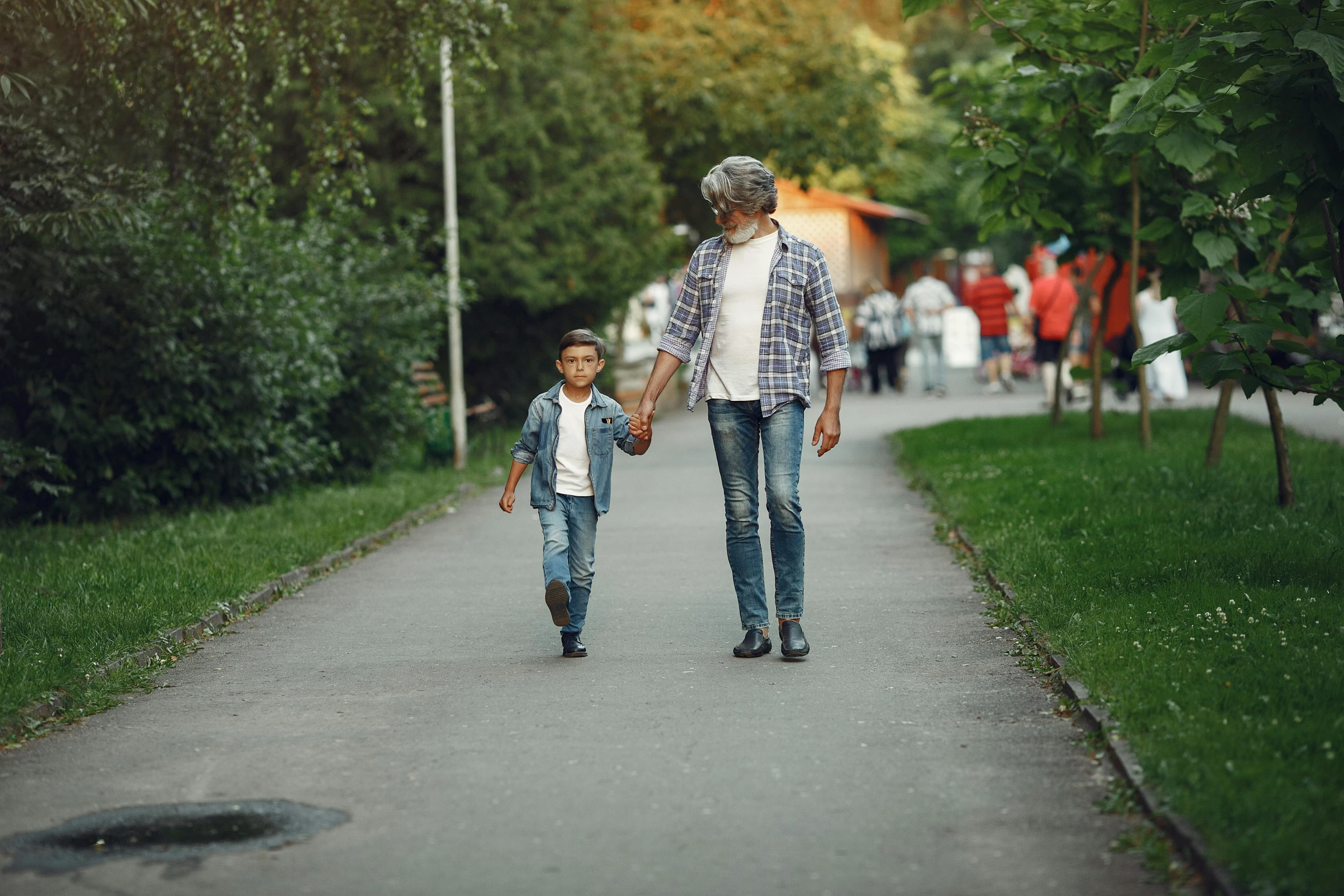 an adult and child walking on a pathway