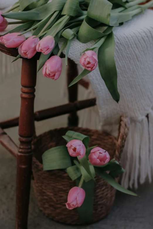 a bouquet of flowers in a wooden vase on a stool