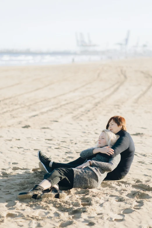 a man and a woman sit on the beach