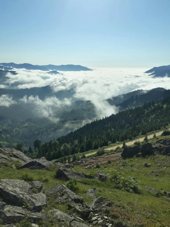 a person standing on a mountain top overlooking a valley filled with clouds