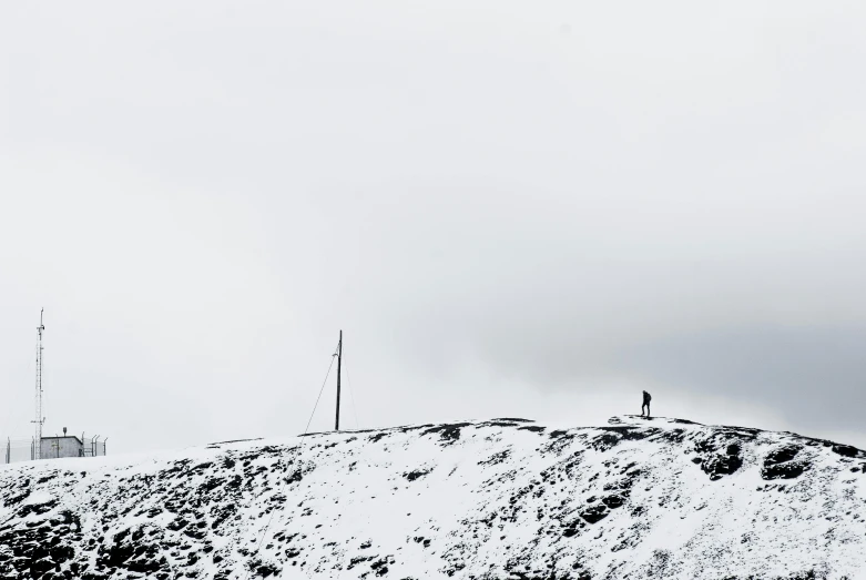two people standing at the top of a snowy hill