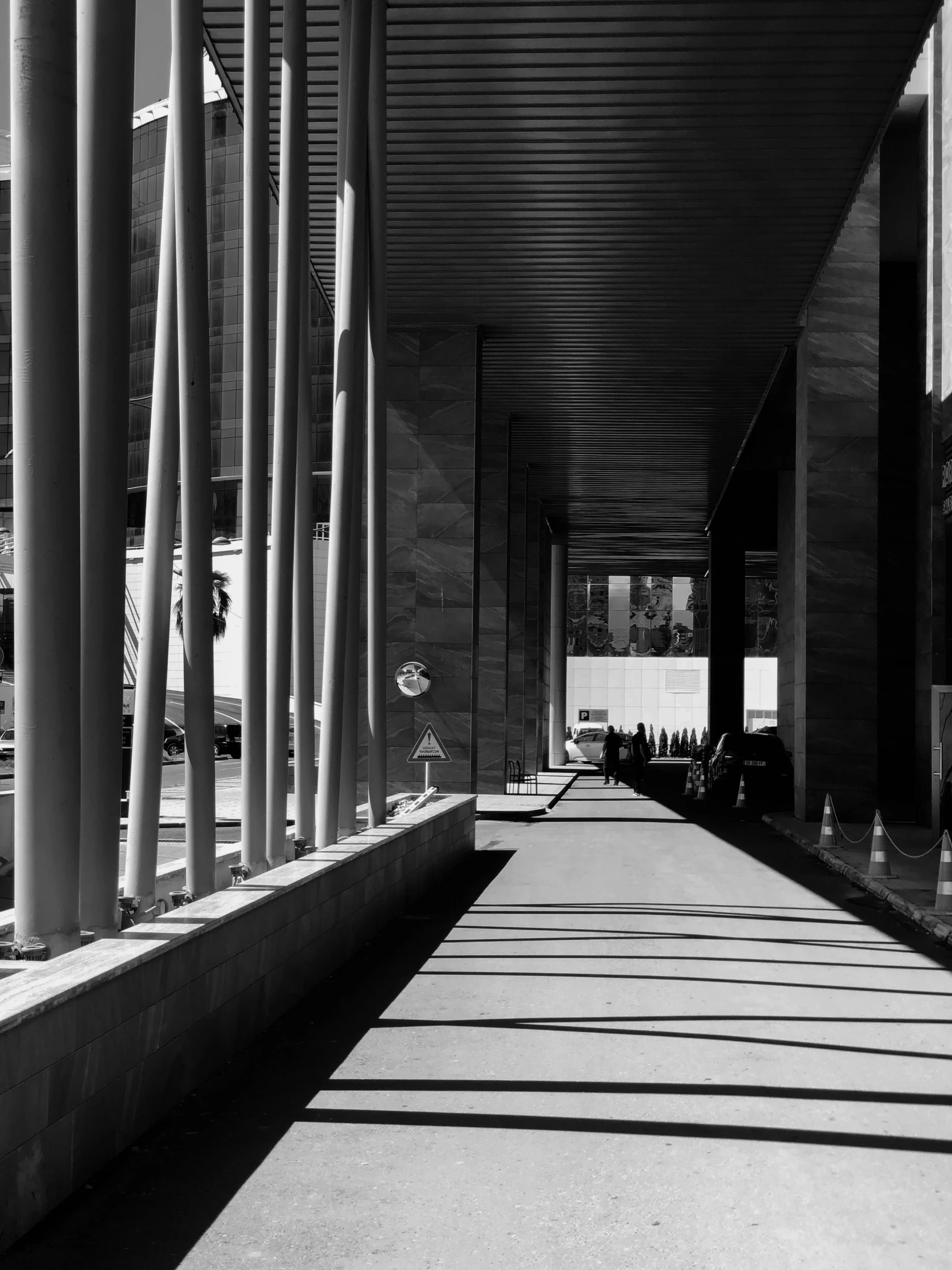 an empty walkway under a cover with many tall columns