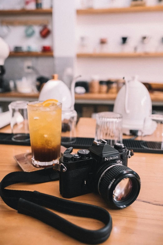 a camera and glass on the table of a coffee shop