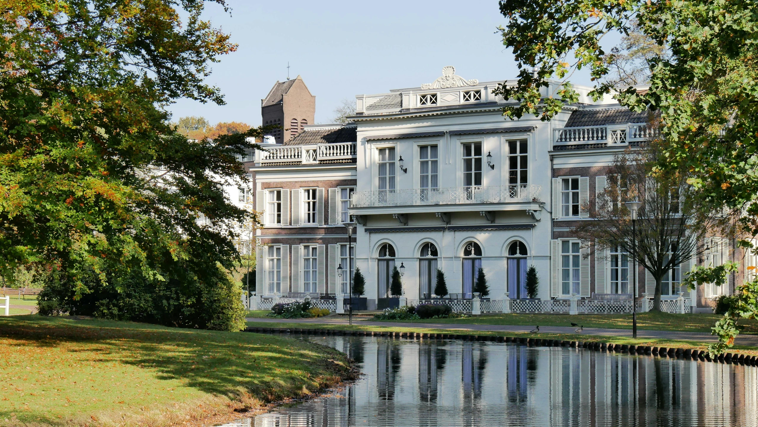 a large old fashioned white building next to a river