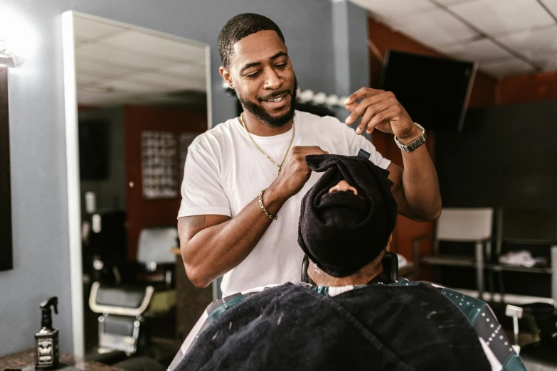 a man is getting his hair cut by a barber