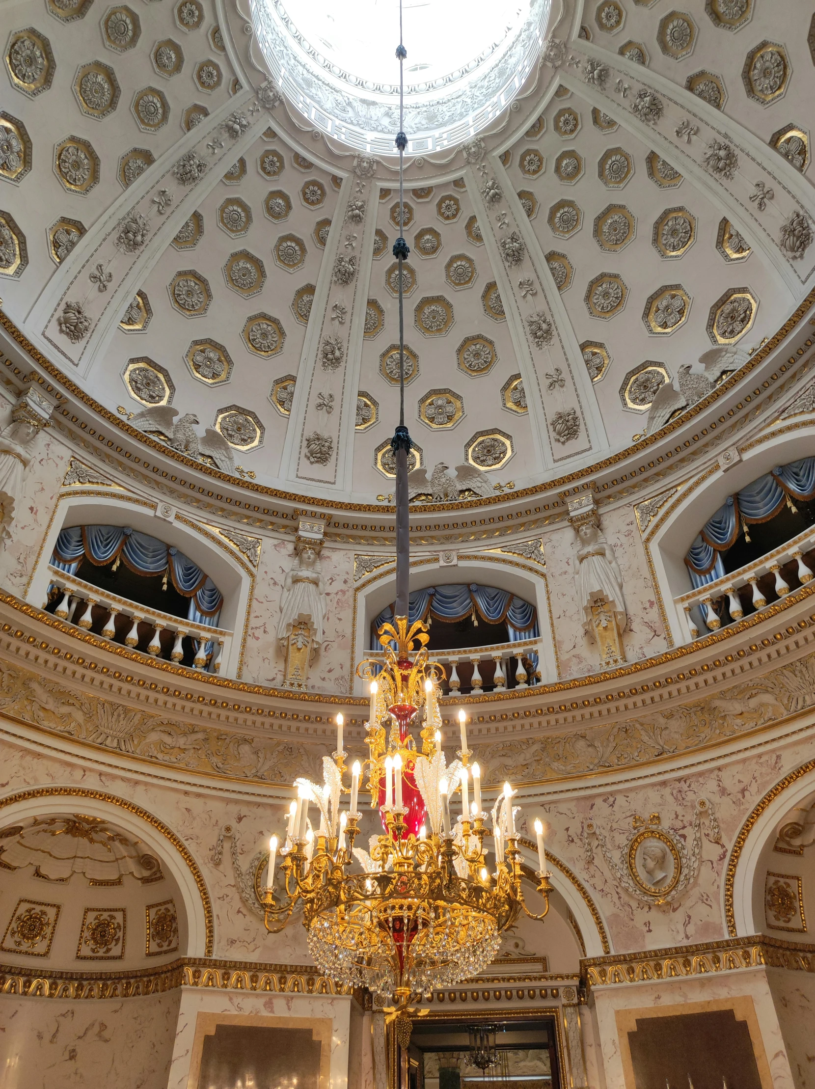 a fancy, decorated round ceiling with chandelier and domed ceiling in a building