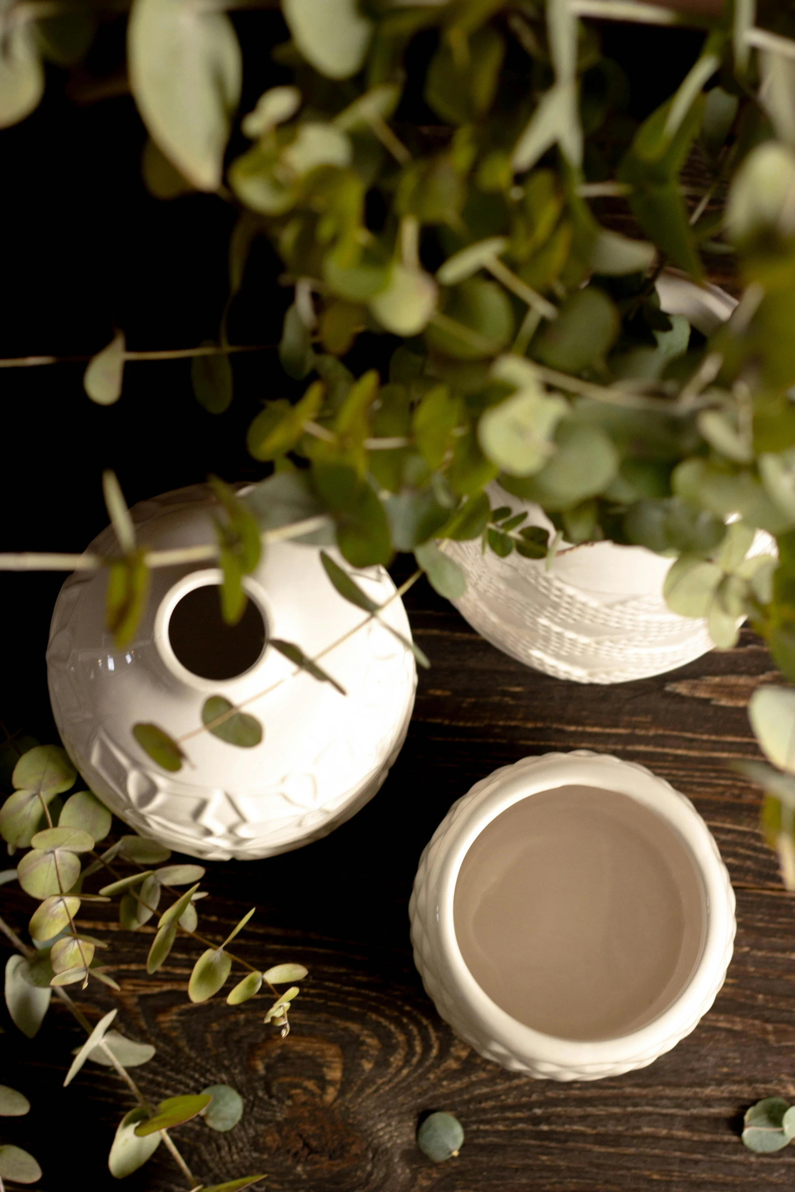 a coffee cup sitting next to a white pottery container