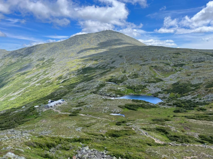 a mountain has a small pond on the side