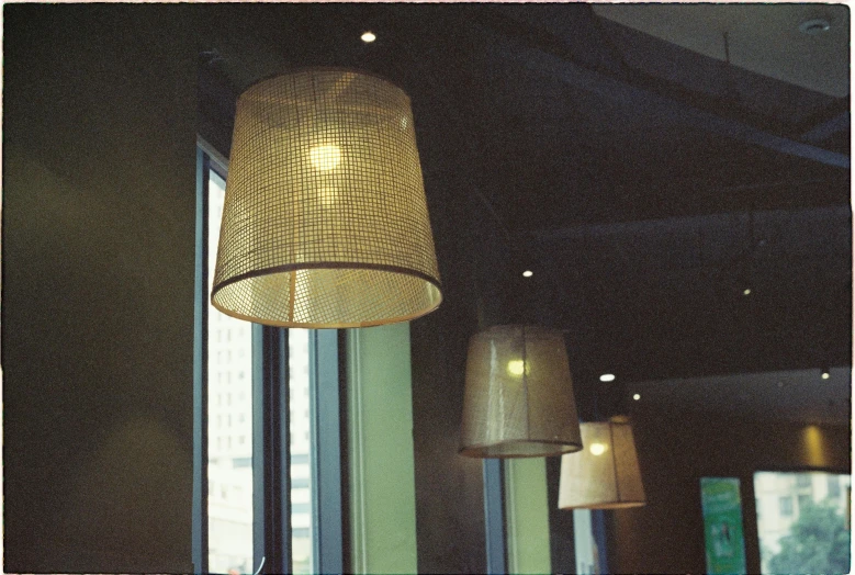 the lights hanging above a restaurant lobby are made from woven fabric