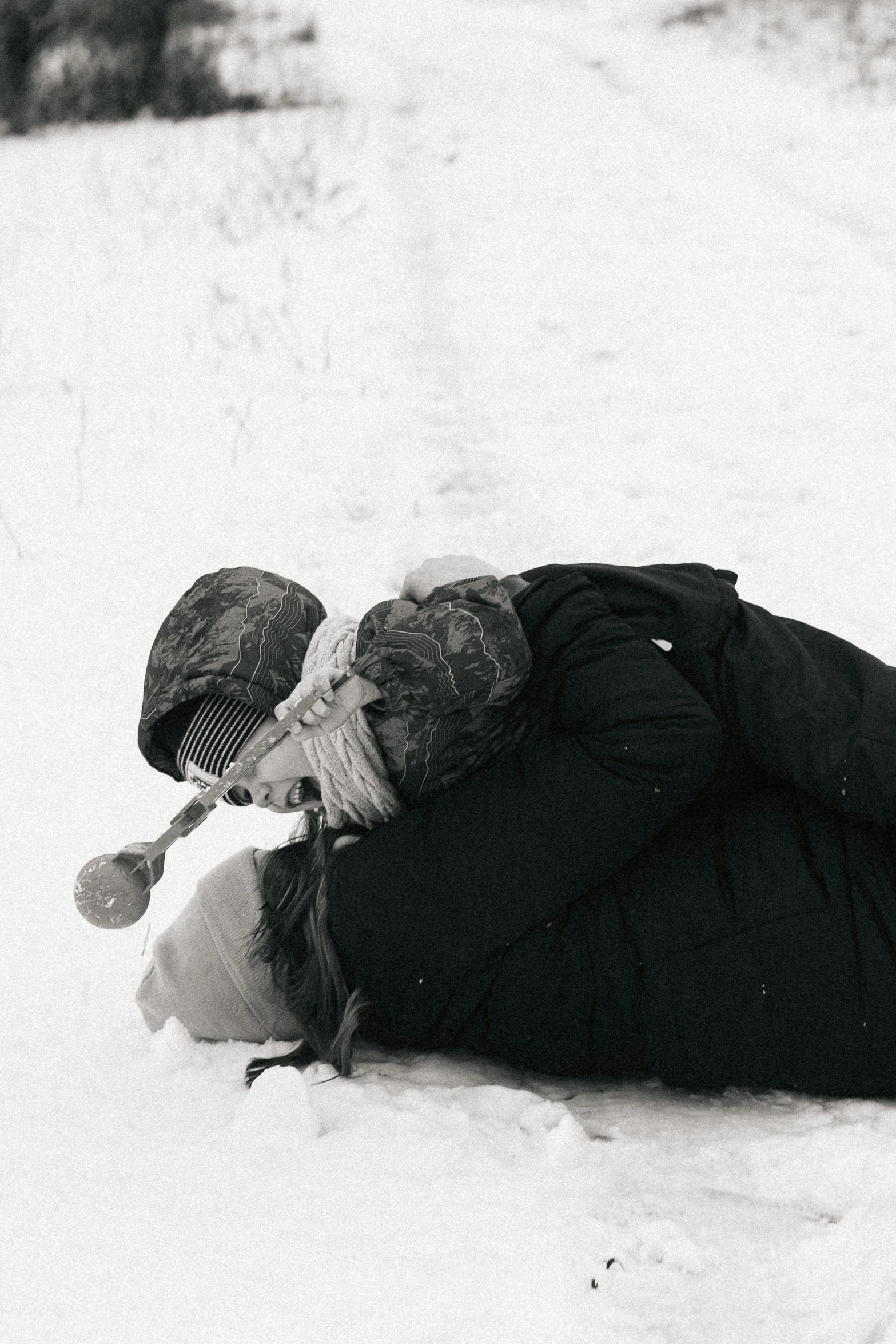 two people are laying down in the snow