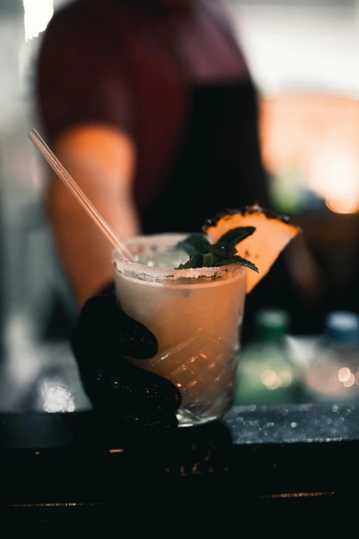 a person is sitting at a bar drinking a drink