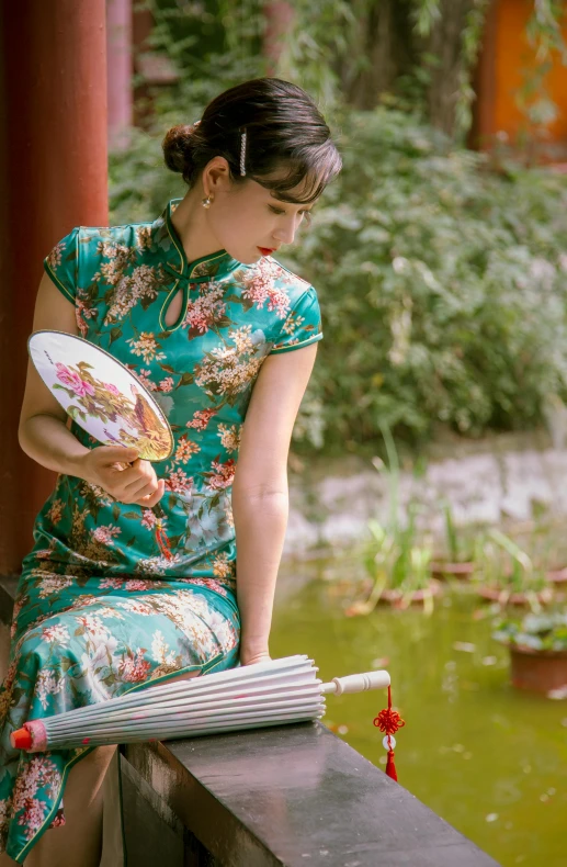 a woman in a blue floral dress holding a frisbee