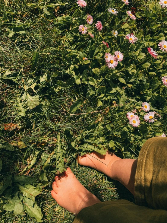 a man laying down on the grass with his legs crossed