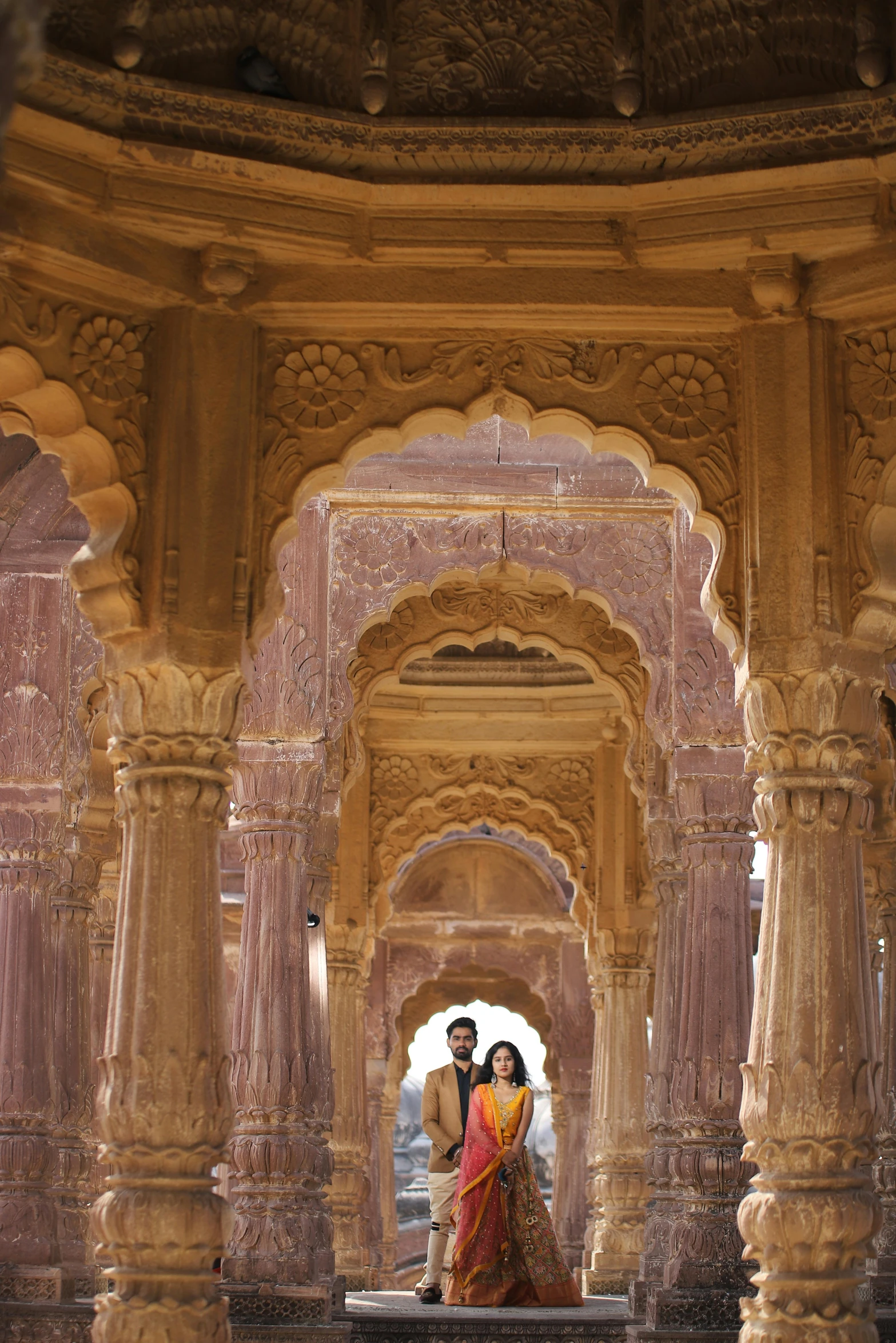 a bride and groom pose for a pograph in an old building