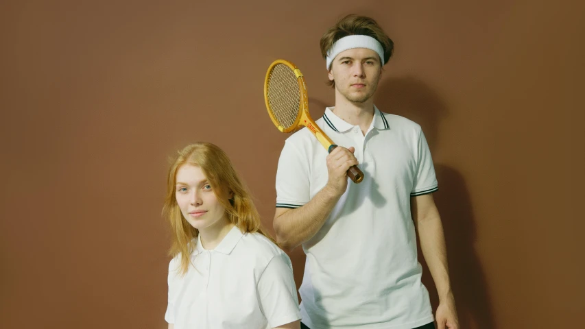 a boy and girl are posing for a po with a tennis racket