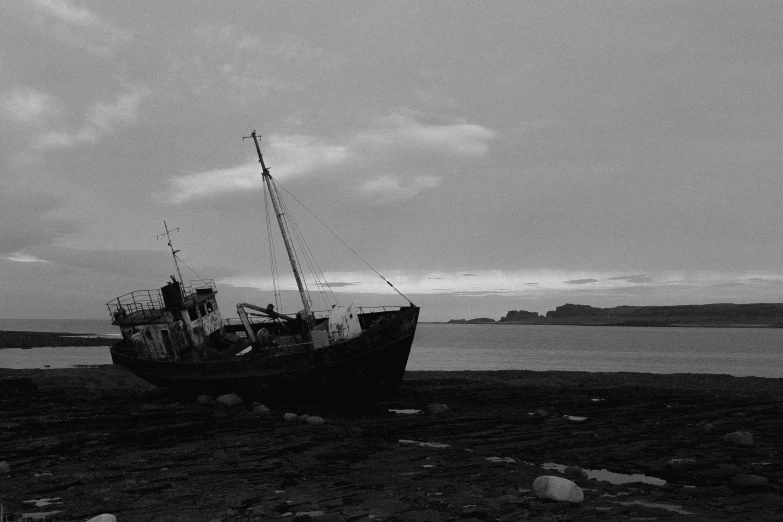 the boat is abandoned in the sea by the rocks