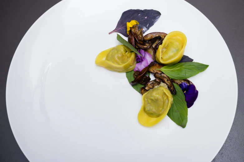 purple flowers and green leaves on a white plate