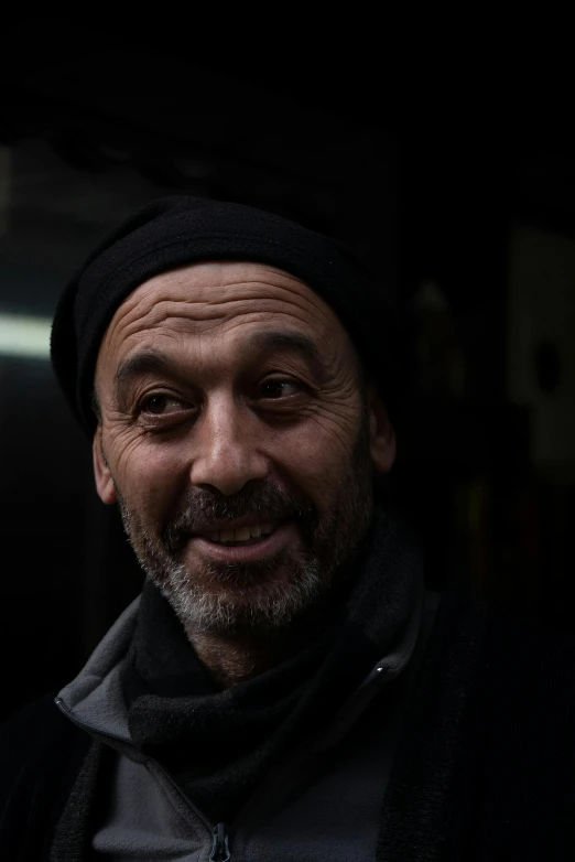 a man wearing a hat and smiling at the camera