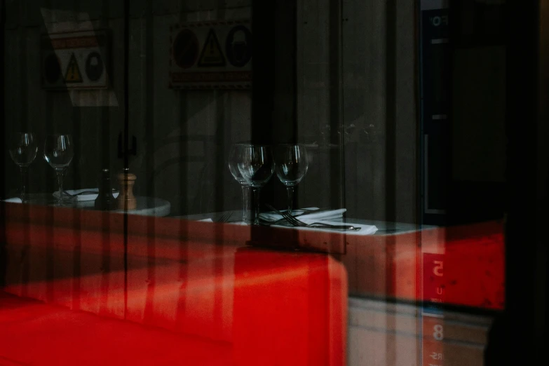 a red sofa sitting on top of a table in front of a window