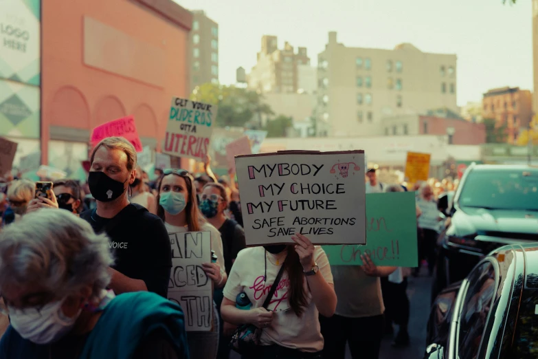 people holding signs and flags on the street