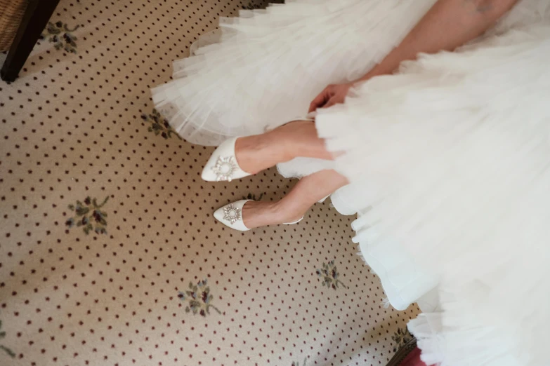 the bride and groom's feet, in high heels, are seen