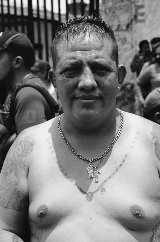 a tattooed man sitting in front of a group of men