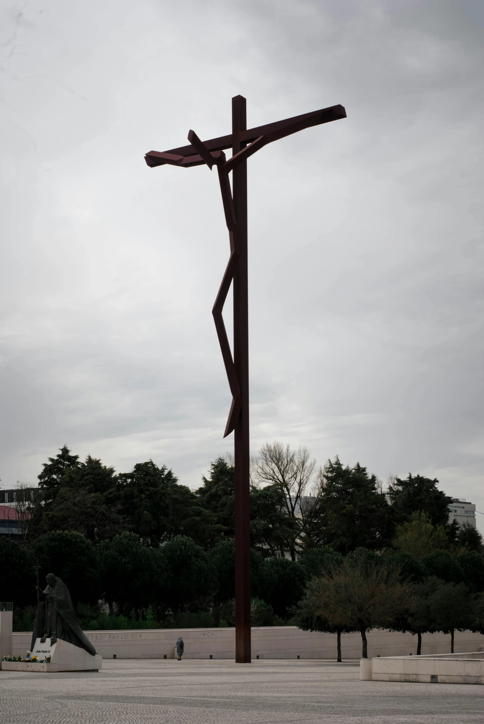 a large cross with wooden posts on the ground