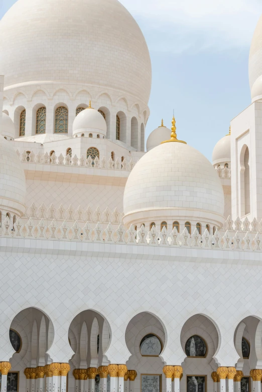 the front view of a white, ornate building with gold trim