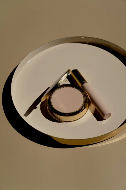 a white plate with a pair of golden scissors and a magnifying glass