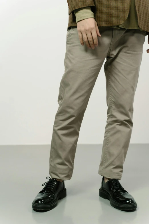 the legs and shoes of a person standing wearing pants