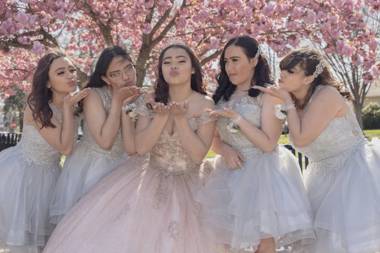 a group of s posing in front of pink trees