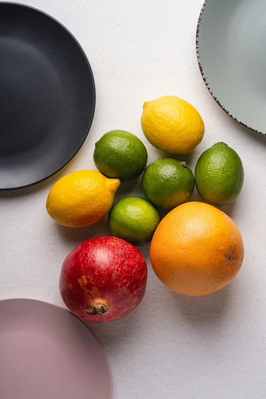 several fruits laying on a counter top next to a bowl