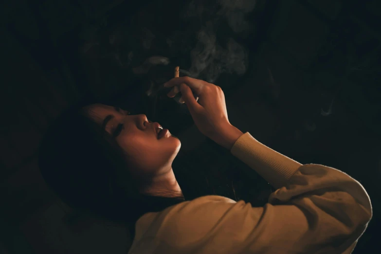 a woman smoking cigarette on her chest with eyes closed