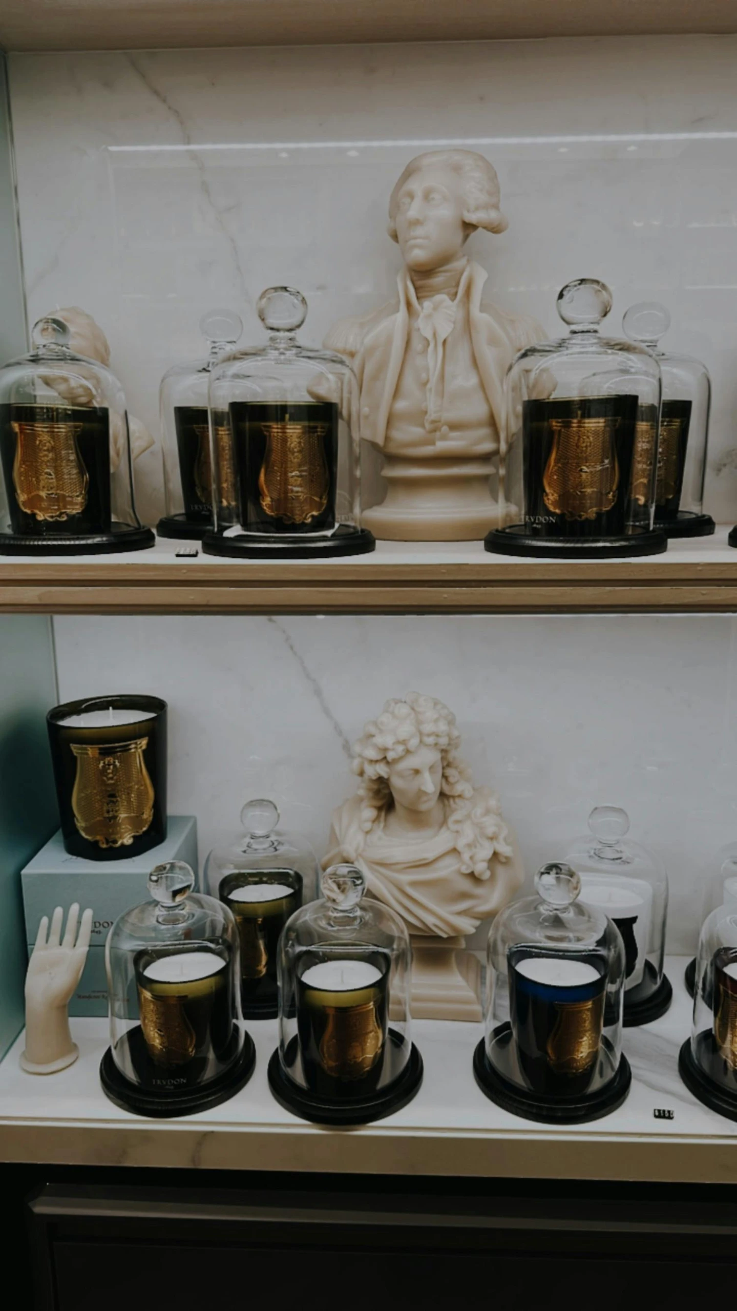 a cabinet with many candle jars and glass holders