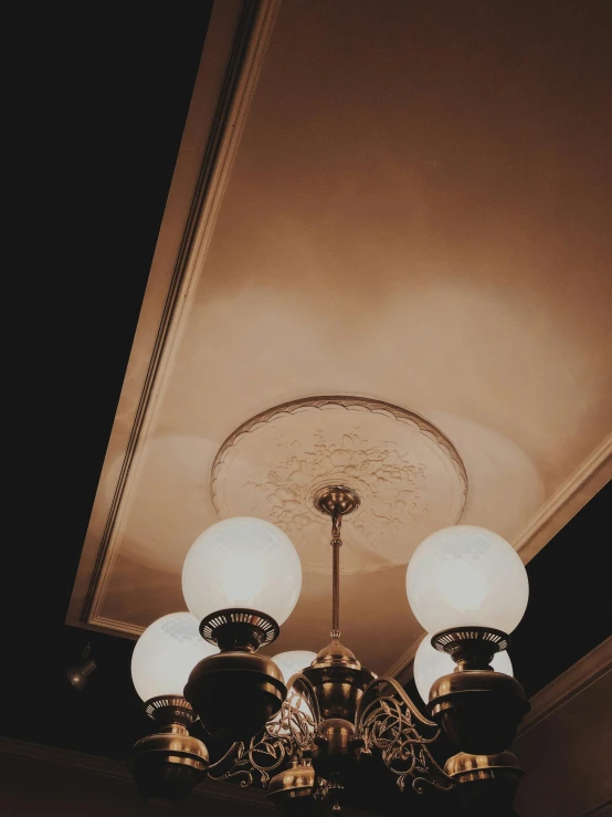 a couple lamps are lit under the lights on a ceiling