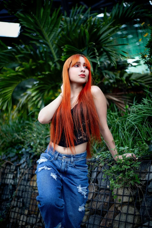 red hair model standing outside in jeans with holes on her skirt