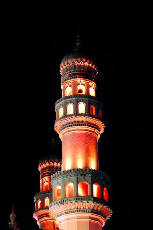 the top of a tall building has lit up windows