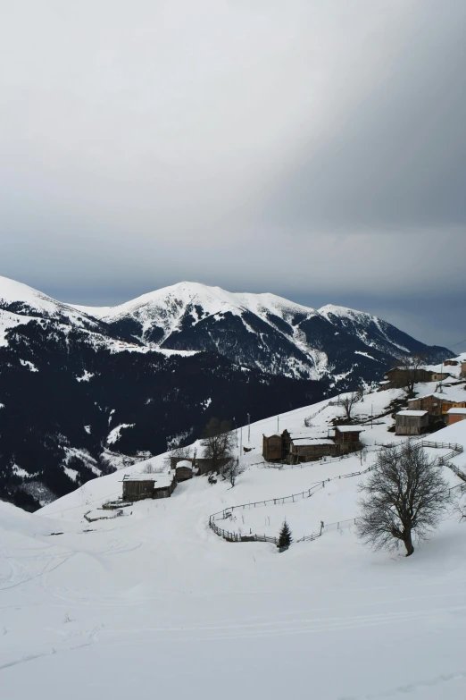 snowy landscape with buildings and mountains in the background