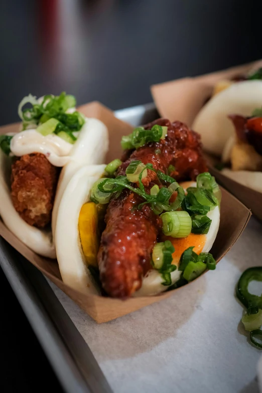 two asian food dishes are on a tray