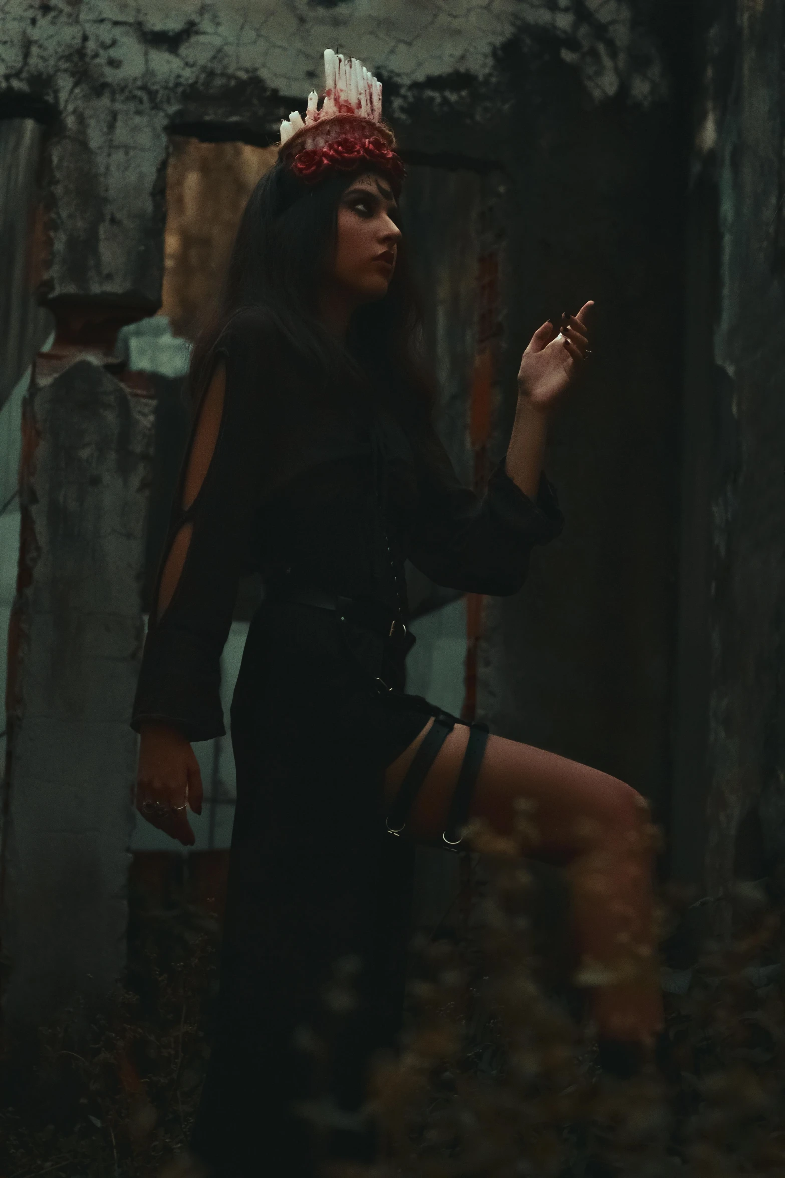 a young lady standing in an abandoned building with her hands in the air