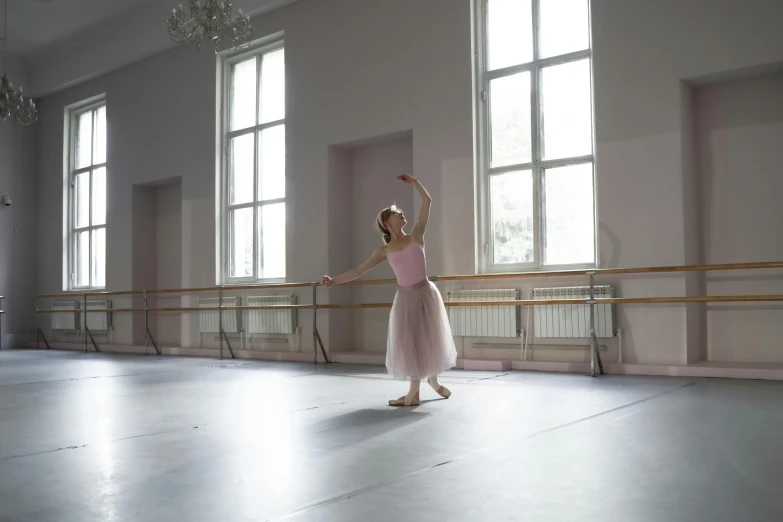 a girl in pink tutu standing in a large room