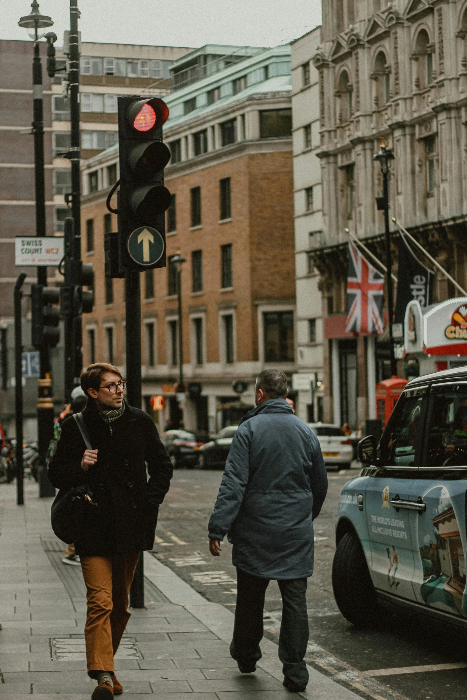 two people are walking down the street in the city