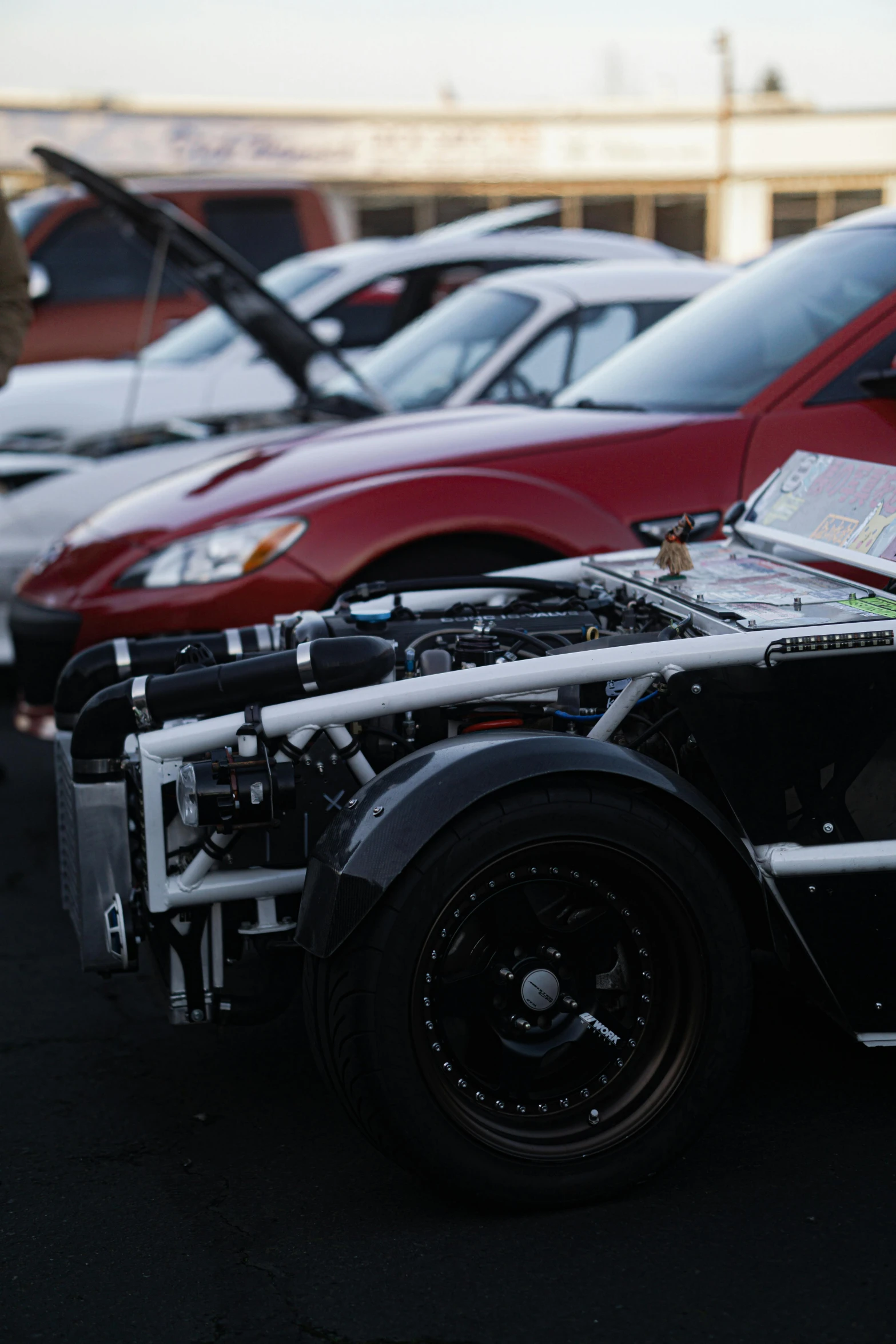 a car with the hood raised at a dealership