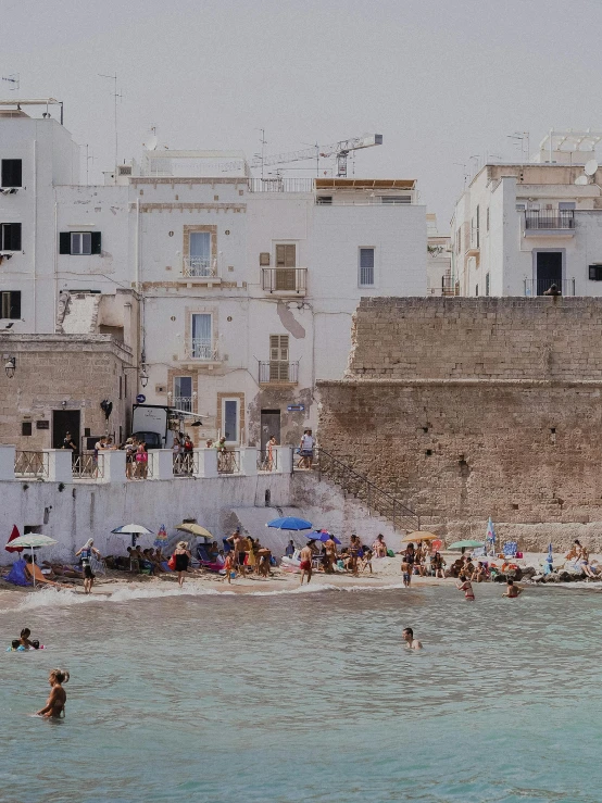 a crowded beach in front of a building