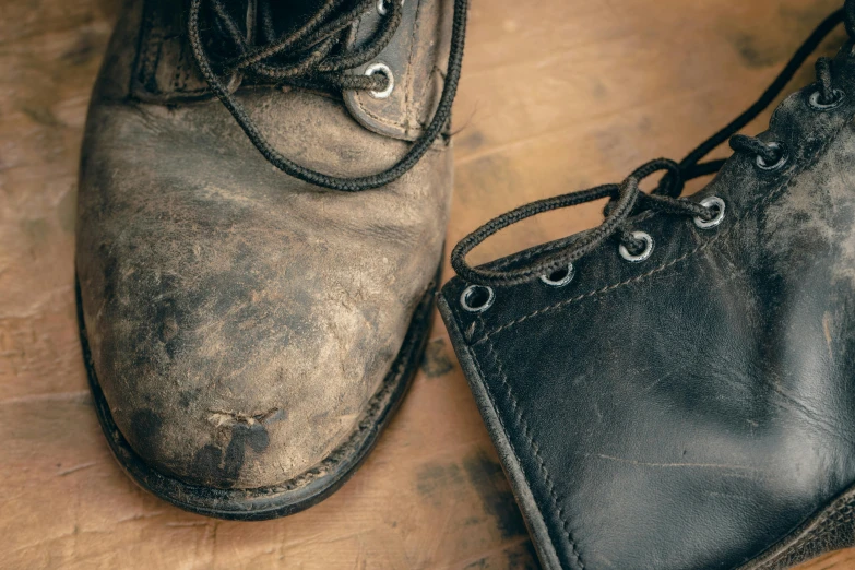 two old black boots that are on the floor