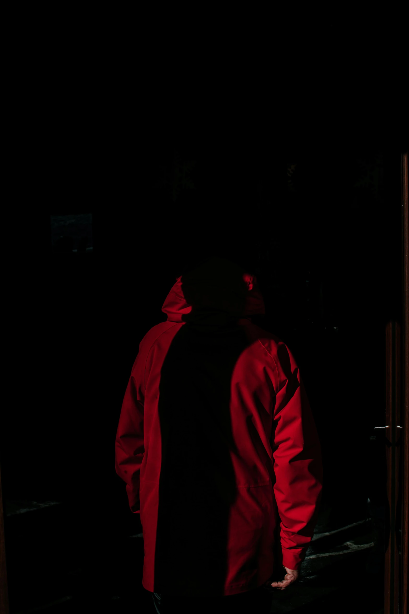 man standing outside in the dark looking down