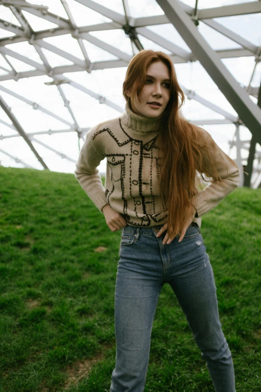 a woman with red hair standing in a field